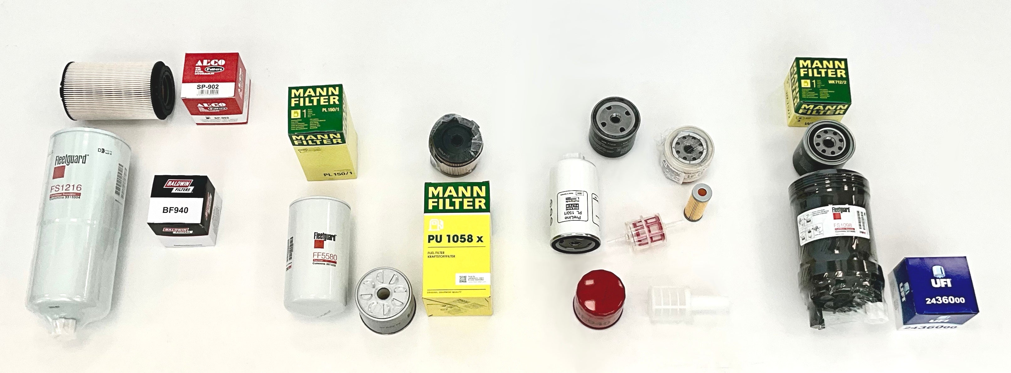 A collection of heavy duty fuel filters arranged on a white background, including Mann Filter, Fleetguard, and UFI products, with their retail packaging, arrange to spell the word 'Fuel'.